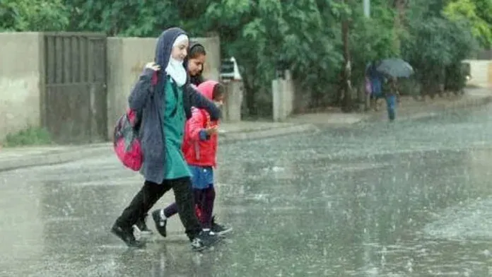مبنى مدرسة وطلاب خلال الطابور الصباحي في بداية الدوام المدرسي